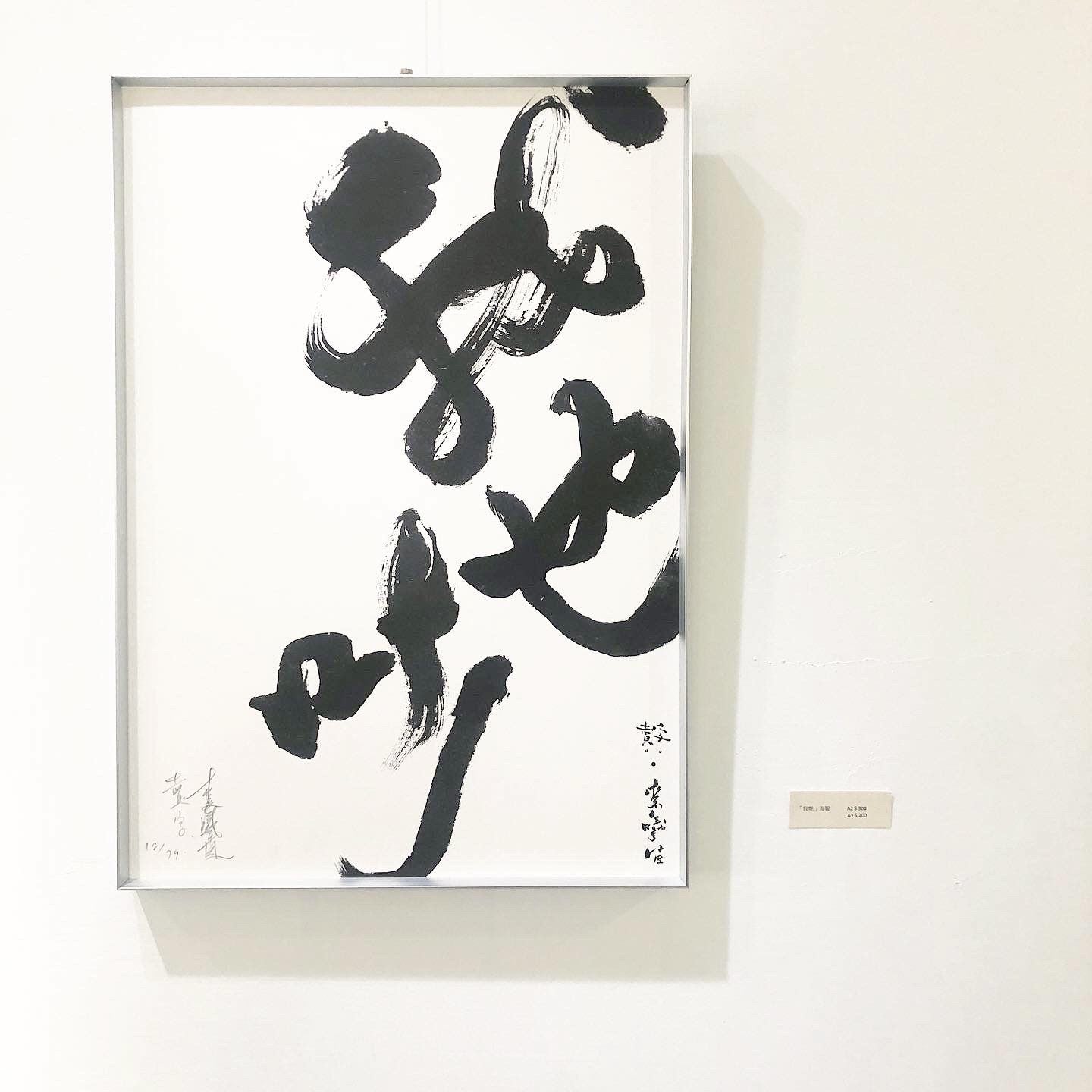 我哋 — Us. A large editioned calligraphy print hanging on a white gallery wall beside its label.