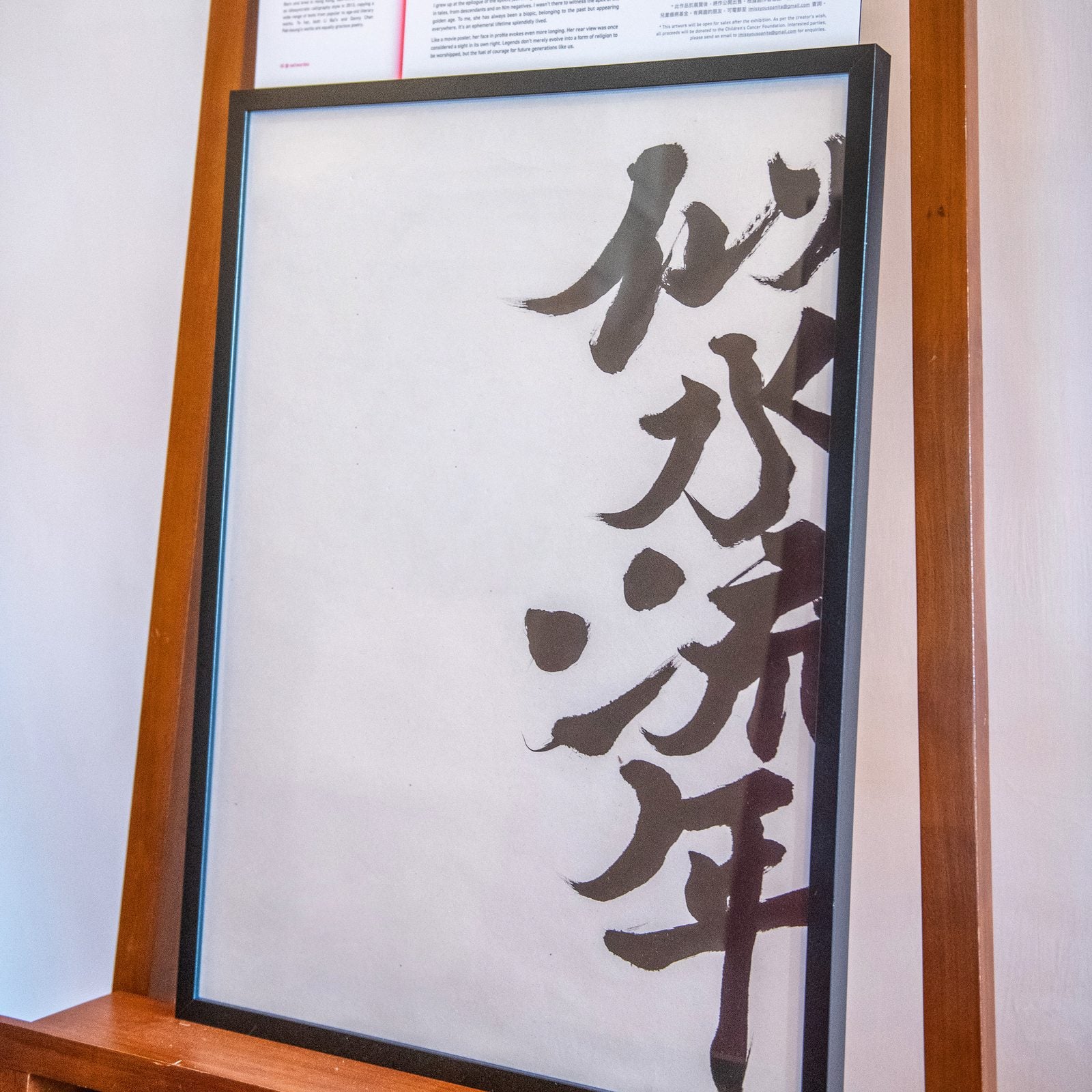 似水流年 — Years Flowing Like Water. A framed work displayed in an exhibition, with wall text behind it.
